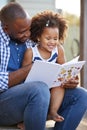 Young black father and daughter reading book outside Royalty Free Stock Photo