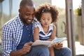 Young black father and daughter reading book outside Royalty Free Stock Photo