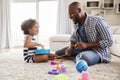 Young black father playing with daughter in the sitting room Royalty Free Stock Photo