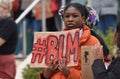 A young black female BLM protester with a sign that reads ` #BLM `