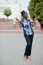 Young black female posed in the city. African women single portrait. She show two fingers