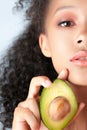 Young black girl with clean perfect skin with avocado close-up