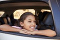 Young black girl looking out of car window smiling, front view Royalty Free Stock Photo