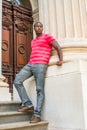 Young black man standing outside office building in New York City, relaxing Royalty Free Stock Photo