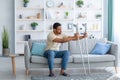 Young black guy having difficulty standing up from sofa, leaning on crutches at home Royalty Free Stock Photo