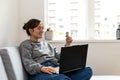 young black-haired woman shopping online from the sofa at home with the computer and credit or debit Royalty Free Stock Photo