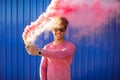 Young black hipster man smiling and holding a colorful pink smoke Royalty Free Stock Photo