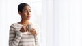 Young Black Lady Drinking Coffee While Standing Near Window At Home Royalty Free Stock Photo
