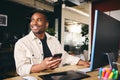 Young Black Male Smiling Advertising Marketing Or Design Creative In Modern Office Sitting At Desk Using Mobile Phone Royalty Free Stock Photo