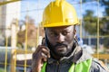 young black man builder employee listening attentively on a phone call