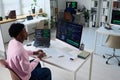 Young Black Man Coding on Computer in Office with Multiple Monitors Royalty Free Stock Photo