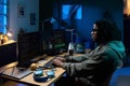 Young Black Man Coding Software on Multiple Computer Monitors at Night Royalty Free Stock Photo