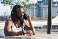 young black man with dreadlocks sitting outdoors at sunset talking on the phone in Puerto Madero Royalty Free Stock Photo