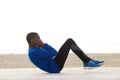 Young black man exercising on the beach doing sit ups Royalty Free Stock Photo