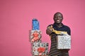 young black man feeling excited while holding a gift box in one hand doing a thumbs up gesture Royalty Free Stock Photo