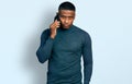 Young black man having conversation talking on the smartphone thinking attitude and sober expression looking self confident Royalty Free Stock Photo