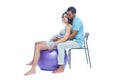 A young black man helps his white wife with birth pain with a ball. Partnered birth, partnered delivery. Isolated white