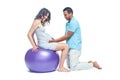 A young black man helps his white wife with birth pain with a ball. Partnered birth, partnered delivery. Isolated white