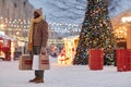 Young Black man holding shopping bags standing in festive Christmas market Royalty Free Stock Photo
