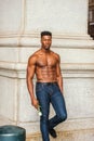 Young black man holding white rose, standing outdoors in New York City, looking forward Royalty Free Stock Photo