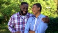 Young black man hugging younger brother laughing having fun together, family