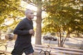 Young black man jogging in a Brooklyn park, close up