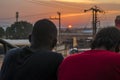 young black man and lady sitting together outside having a conversation and watching the evening sunset