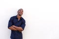 Young black man laughing with arms crossed against white wall Royalty Free Stock Photo