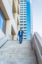 Young black man looking at wristwatch, walking down stairs outside office building in New York City Royalty Free Stock Photo