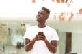 Young black man with mobile phone looking away Royalty Free Stock Photo