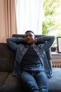 Young Black Man Napping on Sofa with Hands Behind Head Royalty Free Stock Photo