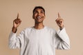 Young black man with piercing laughing while pointing fingers upward Royalty Free Stock Photo