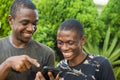 young black man showing a friend something interesting on his mobile phone Royalty Free Stock Photo