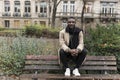 Young Black Man Sitting on Public Park Bench Backrest