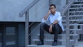 Young Black Man Sitting on Stairs and Talking on Phone Royalty Free Stock Photo