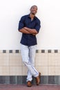 Young black man smiling against white wall with arms crossed Royalty Free Stock Photo