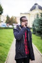 Young black man smiling and talking on mobile phone outside Royalty Free Stock Photo
