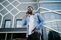 Young black african man smiling and talking on mobile phone outside Royalty Free Stock Photo