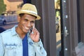 Young black man smiling and talking on mobile phone outside with copy space Royalty Free Stock Photo