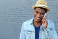 Young black man smiling and talking on mobile phone outside with copy space on the left Royalty Free Stock Photo