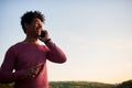 Young black man smiling and talking on mobile phone outside Royalty Free Stock Photo