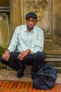 Young black man squatting outdoors in rainy day, in New York City, relaxing Royalty Free Stock Photo