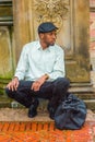 Young black man squatting outdoors in rainy day, in New York City, relaxing Royalty Free Stock Photo