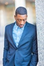 Young black man standing outdoors in New York City, looking down, thinking Royalty Free Stock Photo