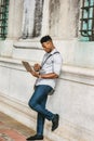 Young black man standing on street in New York City, working on laptop computer Royalty Free Stock Photo