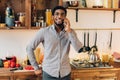 Young black man talking on mobile phone in kitchen Royalty Free Stock Photo