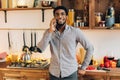 Young black man talking on mobile phone in kitchen Royalty Free Stock Photo