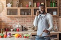 Young black man talking on mobile phone in kitchen Royalty Free Stock Photo