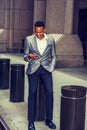 Young black man texting on cell phone on street in New York City Royalty Free Stock Photo