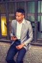 Young black Man texting on cell phone on street in New York City Royalty Free Stock Photo